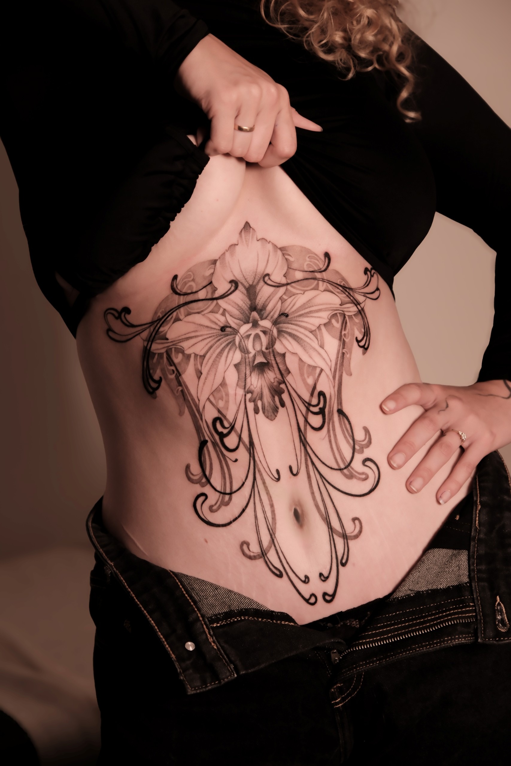 Kreativ blomster tatovering på maven lavet af Pia Meldgaard Tattoo, tatovør i Aarhus C